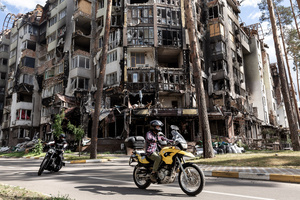 Two motorcyclists are seen in front a residential building destroyed by bombardment. Four months after Russia launched its invasion of Ukraine, fighting has moved from areas around the capital Kyiv to eastern regions. Just 25 kilometers from Kyiv, however, the town of Irpin still bears the scars of heavy fighting and shelling, which reduced many buildings to ruins.