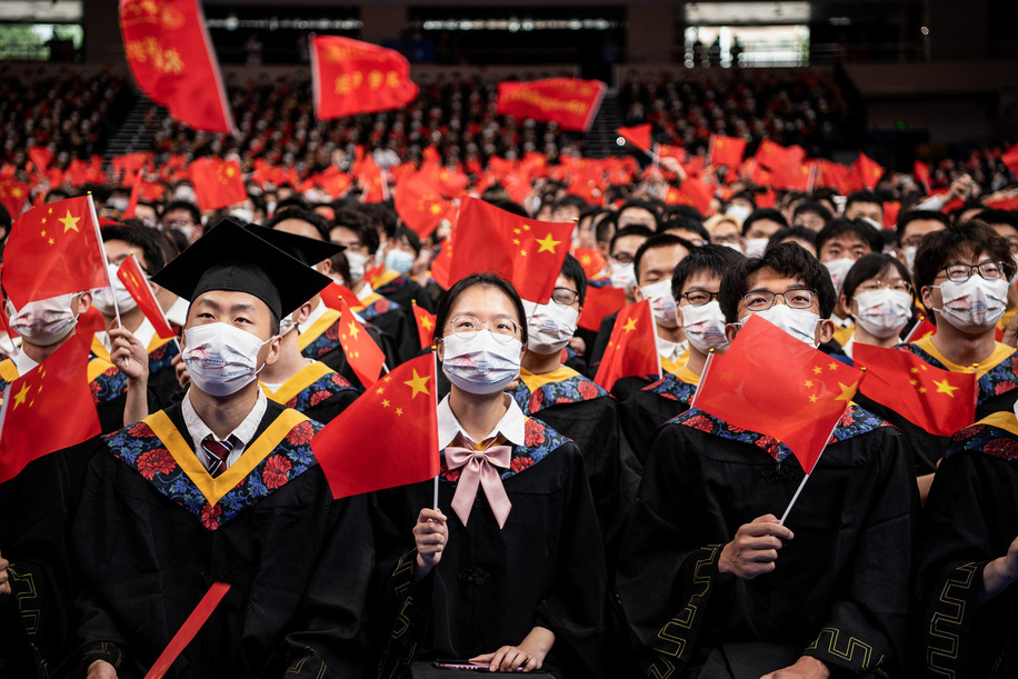 Chinese students from Huazhong University of Science and Technology wave flags while singing during the graduation ceremony in the school's gym. Over the next few weeks, China will record 10.8 million college graduates.