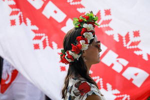 A woman wearing a flower headdress stands in front of a big white-red-white flag at the beginning of the March of dignity dedicated to the 2nd anniversary of the beginning of the protests in Belarus. Belarusian diaspora around the world organized the International day of solidarity with Belarus, dedicated to the anniversary of the presidential elections in Belarus on August 9, 2020. After falsifying the election results and police brutality, hundreds of thousands of people in Belarus went to the street to show their peaceful pro-democracy protest. Repressions dedicated to the pre-election period and post-election period continued till now. Some people were forced to leave Belarus because of security reasons.