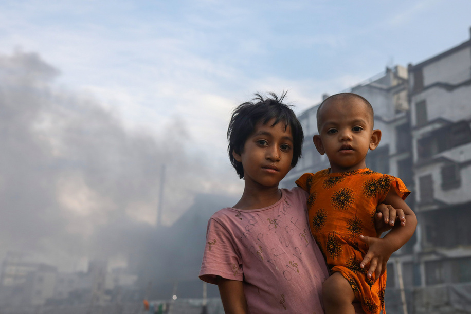 Children pose for a photo in an air polluted atmosphere in Dhaka. Most steel re-rolling mills in and around the capital have been running without the necessary air pollution control system posing a risk of air pollution and health hazard, according to findings of the Department of Environment (DoE).