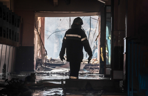 The silhouette of a firefighter is visible in the hallway of a heavily damaged building in Kharkiv as a result of a rocket attack by Russian forces. Russia invaded Ukraine on 24 February 2022, triggering the largest military attack in Europe since World War II.