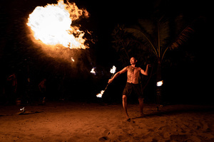 A performer spits kerosene onto a large fire at a beach in Khao Lak. To grow tourism in underserved areas of Thailand, the country's marketing agency, the Tourism Authority of Thailand (TAT), has launched campaigns to promote international tourism to the south as a part of its "Amazing New Chapters" campaign. This specific part of the campaign targets Phuket, Phangan, and Khao Lak.