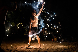 A performer dances with fire at a beach in Khao Lak. To grow tourism in underserved areas of Thailand, the country's marketing agency, the Tourism Authority of Thailand (TAT), has launched campaigns to promote international tourism to the south as a part of its "Amazing New Chapters" campaign. This specific part of the campaign targets Phuket, Phangan, and Khao Lak.