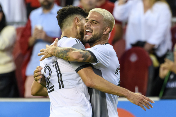 Lorenzo Insigne (24) celebrates with teammate Jonathan Osorio (21) during the MLS game between Toronto FC and Portland Timbers SC at BMO field. The game ended 3-1 for Toronto FC.