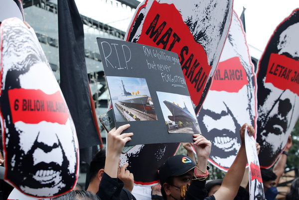 Protesters are seen holding placards during the demonstration. Protesters gathered outside a shopping complex demanding the government to form a royal commission of inquiry following the release of a report by Parliament's Public Accounts Committee on the controversial RM9 billion littoral combat ship (LSC) project.