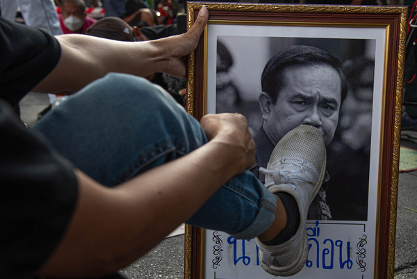 A protester steps on a portrait of a Thailand's Prime Minister Prayut Chan-o-cha during the demonstration. Anti-government protesters gathered at the Victory monument demanding the resignation of Thailand's Prime Minister Prayut Chan-o-cha after his return to office following the constitutional court ruling on 30 September 2022.