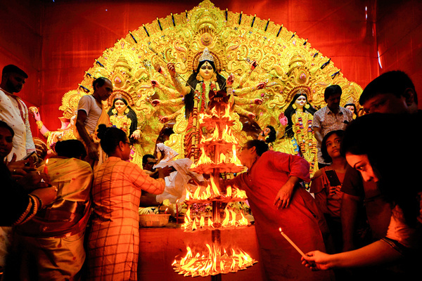 Hindu devotees light Diyas (clay made lamps) in front of the idol of Lord Durga during the Sandhi Puja Ritual of Durga Ashtami at a Pandal (Temporary place of Worship) in Kolkata. Sandhi Puja is the junction time between the Eighth & Ninth day of Durga Puja when 108 Diyas are lit up for the Hindu traditional ritual. The Hindu people believe these lights will eliminate all the darkness from every corner of their lives.