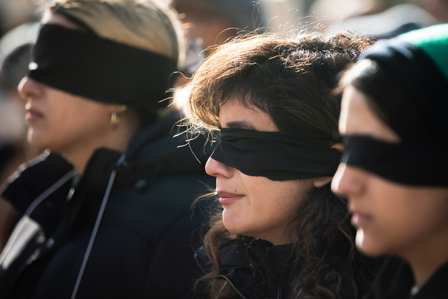 Young women are seen wearing a black blindfold during a rally in support of people in Iran and Ukraine