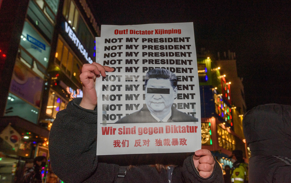 A protester holds a placard denying Chinese president; Xi Jinping during a vigil in Seoul commemorating victims of China's Covid Zero policy. South Korean protesters took to the streets of Seoul after a deadly apartment fire in Xinjiang province of China sparked a national Chinese outcry as many blamed the COVID lockdown restrictions for the deaths.