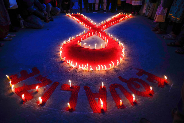 People from Maiti Nepal, a rehabilitation center for victims of trafficking and home for the HIV-affected, light candles around a red ribbon on the eve of World AIDS Day. On December 1st, World AIDS Day is observed every year to raise awareness and support for those living with HIV/AIDS.