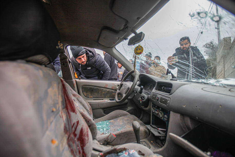 Palestinians inspect the car in which two Palestinians were killed by Israeli army during their pursuit, after they opened fire on a military post, in the town of Jaba, near Jenin, in the occupied West Bank.