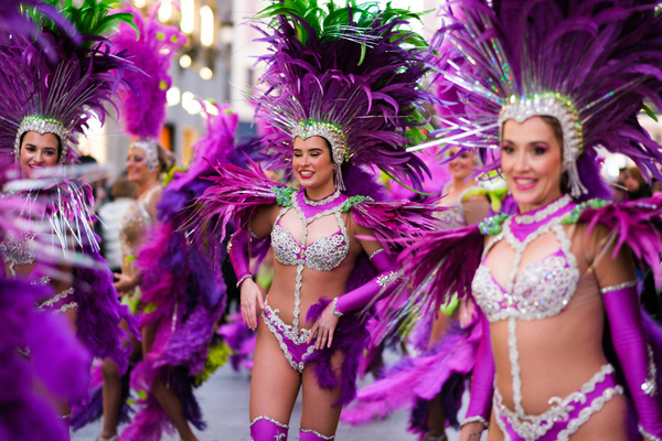 Several women dressed in carnival costumes dance during the parade of the presentation act of the Carnival festivities of the city of Torrevieja organized by the FITUR tourism fair, in the Preciados street of Madrid.