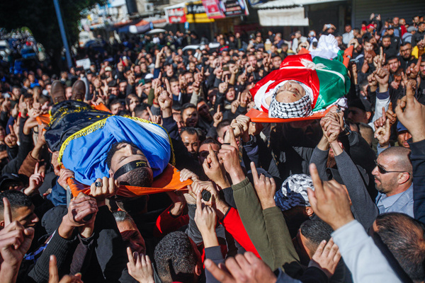 (EDITOR'S NOTE: Image depicts death)
Mourners and armed men carry the bodies of Palestinians, Adham Jabareen, 28 years old, left, and school teacher Jawad Bawaqna, 57 years old, right, who were killed by Israeli army bullets during a raid on the Jenin refugee camp, during their funeral ceremony in the city of Jenin in the occupied West Bank. Eyewitnesses said that Jabareen was shot dead by the Israeli army during a gun clashes , and the school teacher Bawaqnah tried to provide first aid to him after he fell to the ground. During his attempt to help him, an Israeli sniper shot him, and after that the Israeli forces prevented ambulances and medical personnel from entering the area, which resulted in the killing of the two and six other injuries. Bawakneh worked as a physical education teacher at a local Palestinian school.