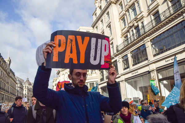 A protester holds a 'Pay up' placard during the demonstration in Regent Street. Thousands of teachers and supporters marched in central London as teachers across the country begin their strike over pay. The day has seen around half a million people staging walkouts around the UK, including teachers, university staff, public service workers and train drivers.