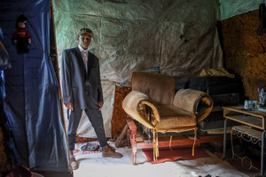 A 23-Year-Old, Chara Alolo, a poet from Kibera slums poses in his house in Kibera. The young Kenyan youths are driven into a competency of having their own homes away from their parents where they, most importantly, learn to tackle life through different challenges. The competition to have the best-decorated rooms filled with different designer outfits is one way of avoiding daily difficulties such as drug abuse, teenage pregnancies, early marriages, and negative judgments from locals. To most young youths having a home is the start of a new life, and it comes with many responsibilities. Unauthorized housing is the most lucrative investment in Kenya today. Therefore for one to have a house with landlords renting rooms to let at Ksh 1,500 ($ 12) to Ksh 5000 ($ 40) a month, that is almost too hard to pay for most youths with low-income jobs and therefore needs an extra effort to raise their sources of income.