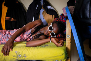 A 23-Year-Old Mosi Belyn poses inside a bedroom with a wall closet arrangement in Kibera. The young Kenyan youths are driven into a competency of having their own homes away from their parents where they, most importantly, learn to tackle life through different challenges. The competition to have the best-decorated rooms filled with different designer outfits is one way of avoiding daily difficulties such as drug abuse, teenage pregnancies, early marriages, and negative judgments from locals. To most young youths having a home is the start of a new life, and it comes with many responsibilities. Unauthorized housing is the most lucrative investment in Kenya today. Therefore for one to have a house with landlords renting rooms to let at Ksh 1,500 ($ 12) to Ksh 5000 ($ 40) a month, that is almost too hard to pay for most youths with low-income jobs and therefore needs an extra effort to raise their sources of income.