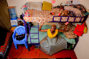 A 23-Year-Old model Risper Atieno poses on her bed in her room in the Kibera Slum. The young Kenyan youths are driven into a competency of having their own homes away from their parents where they, most importantly, learn to tackle life through different challenges. The competition to have the best-decorated rooms filled with different designer outfits is one way of avoiding daily difficulties such as drug abuse, teenage pregnancies, early marriages, and negative judgments from locals. To most young youths having a home is the start of a new life, and it comes with many responsibilities. Unauthorized housing is the most lucrative investment in Kenya today. Therefore for one to have a house with landlords renting rooms to let at Ksh 1,500 ($ 12) to Ksh 5000 ($ 40) a month, that is almost too hard to pay for most youths with low-income jobs and therefore needs an extra effort to raise their sources of income.