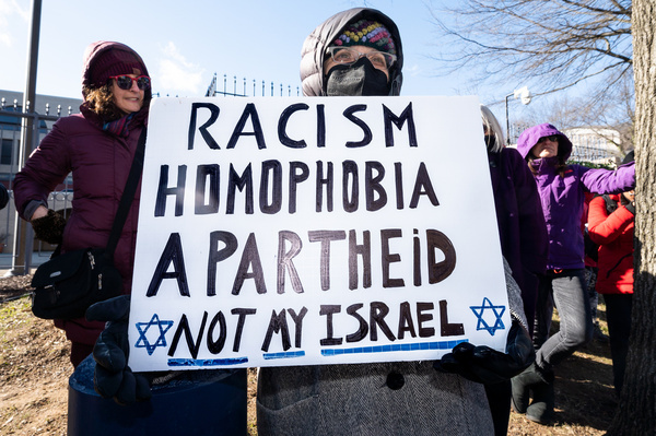 Woman holds a placard saying "Racism homophobia apartheid not my Israel" during a rally in support of Israeli Democracy at the Israeli Embassy in Washington, DC.