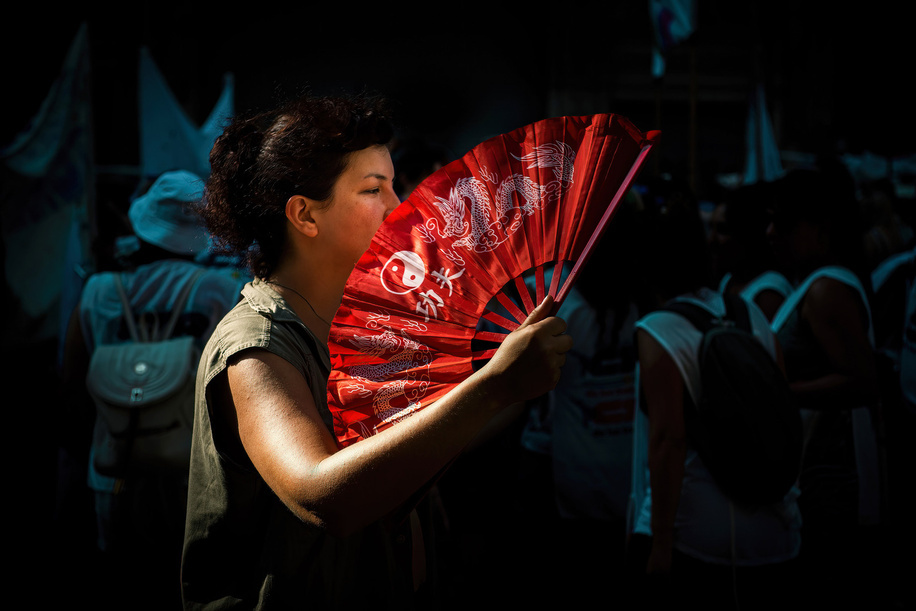 A woman holds a fan during a rally to support women's rights on International Women's Day in Buenos Aires. Thousands of people attend a rally to support women's rights on International Women's Day.