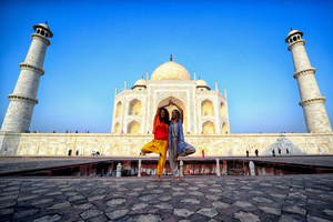Foreign Tourists seen posing in different Yoga (Physical exercise) styles in front of the Taj Mahal in Agra. The Taj Mahal is a mausoleum located in the right bank of the river Yamuna - Agra, India, built by Mughal Emperor Shah Jahan in memory of his favorite wife, Mumtaz. The Taj Mahal is considered the finest example of Mughal architecture, a style that combines elements from Persian, Oman, Indian, and Islamic architectural styles. The Taj Mahal is in the list of modern Seven Wonders of the World and It has also been a protected UNESCO World Heritage Site since 1983.
