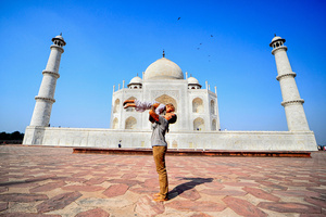 A mother seen kissing her baby in front of the Taj Mahal in Agra. The Taj Mahal is a mausoleum located in the right bank of the river Yamuna - Agra, India, built by Mughal Emperor Shah Jahan in memory of his favorite wife, Mumtaz. The Taj Mahal is considered the finest example of Mughal architecture, a style that combines elements from Persian, Oman, Indian, and Islamic architectural styles. The Taj Mahal is in the list of modern Seven Wonders of the World and It has also been a protected UNESCO World Heritage Site since 1983.