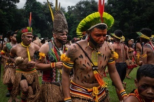 A group of indigenous people wearing ornaments seen dancing and singing during the celebrations of the Indigenous People’s Day, at the Aldeia Katurãma.