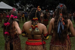 Backs of indigenous women wearing traditional outfits and ornaments during the celebrations of the Indigenous Peoples Day, at the Aldeia Katurãma.