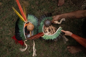 The head ornaments (cocar) and music instruments seen laying on the grass during the celebrations of the Indigenous People’s Day, at the Aldeia Katurãma.