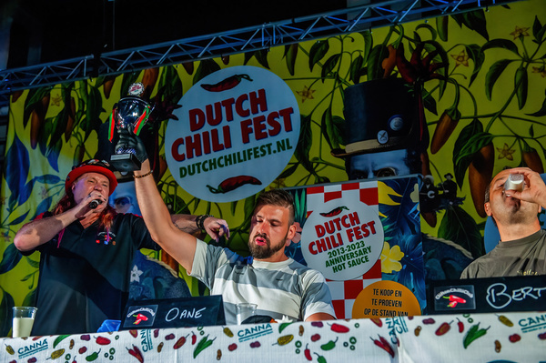 The winner of one of the rounds seen raising his trophy. The Dutch Chili Fest attracts thousands of visitors every year who enjoy watching the chili pepper-eating contest participants crying and sweating while eating the hottest chili peppers.