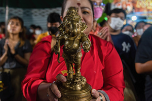 A Hindu devotee holds a statue of Hindu god Lord Ganesha during a ceremony to mark the Ganesh Chaturthi festival at Wat Khaek in Bangkok. The Ganesh Chaturthi is a Hindu festival to commemorate the birth of the Hindu god Lord Ganesha.