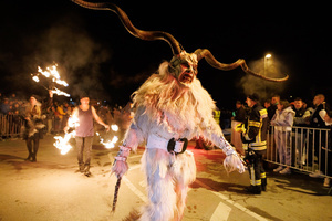 A Krampus walks by during a Krampus run. More than 600 Krampuses from Slovenia, Austria, Italy, and Croatia joined the tenth anniversary of the Krampus run in Goričane. Krampus, a horned demon-like figure, traditionally works alongside Saint Nicholas or Santa Claus. While Santa rewards good children with gifts, Krampus scares and gives birch rods to misbehaving children. The Krampus run aims to remind both children and adults who haven't been well-behaved to improve their behavior before Christmas.