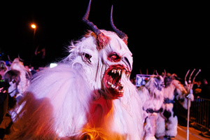 A Krampus walks by during a Krampus run. More than 600 Krampuses from Slovenia, Austria, Italy, and Croatia joined the tenth anniversary of the Krampus run in Goričane. Krampus, a horned demon-like figure, traditionally works alongside Saint Nicholas or Santa Claus. While Santa rewards good children with gifts, Krampus scares and gives birch rods to misbehaving children. The Krampus run aims to remind both children and adults who haven't been well-behaved to improve their behavior before Christmas.