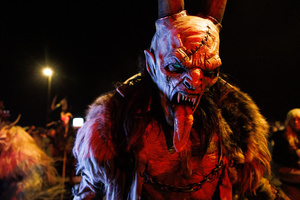 A Krampus walks by during a Krampus run. More than 600 Krampuses from Slovenia, Austria, Italy, and Croatia joined the tenth anniversary of the Krampus run in Goričane. Krampus, a horned demon-like figure, traditionally works alongside Saint Nicholas or Santa Claus. While Santa rewards good children with gifts, Krampus scares and gives birch rods to misbehaving children. The Krampus run aims to remind both children and adults who haven't been well-behaved to improve their behavior before Christmas.
