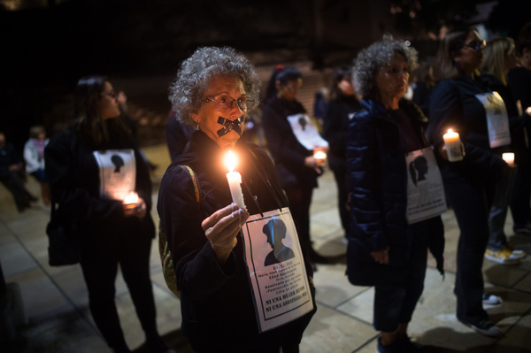 A woman with her mouth gagged is seen holding a candle and a placard as she takes part in the performance 'Walk of silence' against gender violence. In commemoration of the International Day for the Elimination of Violence against Women, dozens of women took part in a Caminata Del Silencio (Walk of silence) against gender-based sexual violence. They march every year along the streets in Malaga holding candles and placards with the names of all women who were killed by their partners in Spain.