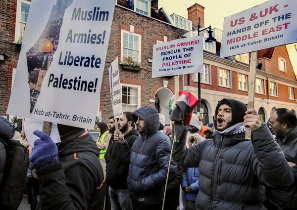 Supporters chant with speakers holding placards calling for Muslim Armies to liberate Palestine and for the US and UK to keep their hands off the Middle East. Hizb ut-Tahrir hold a static protest opposite the Egyptian embassy calling for Muslim armies to rescue the Palestinian people. Conditions under section 14 of the Public Order Act mean they are unable to leave Balfour Mews. Hizb ut-Tahrir states its aim as unification of all Muslim lands over time in a unitary Islamic state or caliphate and to implement sharia globally.