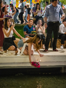 A young woman is seen putting her krathong in the lake during the Magical Loy Krathong Festival at Jodd Fairs Dan Neramit in Bangkok. Loy Krathong, Thailand's Festival of Lights, is celebrated annually across Thailand and nearby regions. During this festival, people float decorated baskets made of banana leaves, incense sticks, and candles on rivers, canals, or ponds. They make wishes as they release these floating offerings.