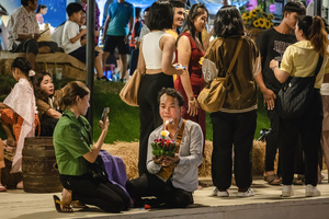 A woman is seen taking a picture of her husband with his krathong on the lake during the Magical Loy Krathong Festival at Jodd Fairs Dan Neramit in Bangkok. Loy Krathong, Thailand's Festival of Lights, is celebrated annually across Thailand and nearby regions. During this festival, people float decorated baskets made of banana leaves, incense sticks, and candles on rivers, canals, or ponds. They make wishes as they release these baskets.