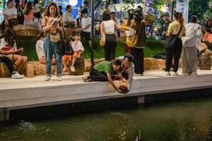 A Thai couple are seen carrying a krathong to put it on the lake during the Magical Loy Krathong Festival at Jodd Fairs Dan Neramit in Bangkok. Loy Krathong, Thailand's Festival of Lights, is celebrated annually across Thailand and nearby regions. During this festival, people float decorated baskets made of banana leaves, incense sticks, and candles on rivers, canals, or ponds. They make wishes as they release these floating offerings.