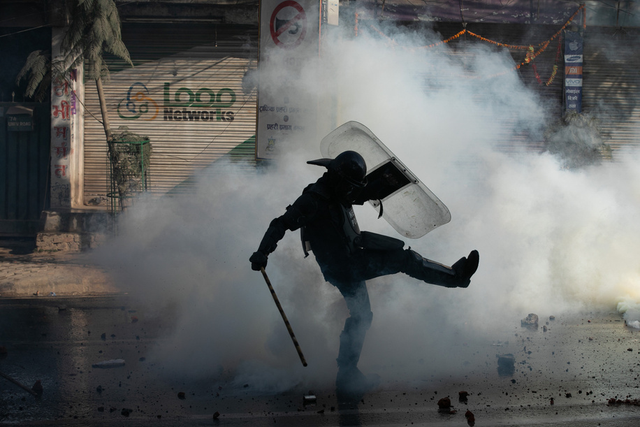 Nepal Police personnel kicks a tear gas shell during a demonstration against the Nepal's Federal Democratic Republic system at Balkhu. The supporters of pro-monarchy and businessman Durga Parsai demanded the return of Nepal's monarchy, and the clashes erupted as they made their way towards Maitighar, which had just been declared a prohibited zone. 
The police used tear gas and water cannons to control the situation.