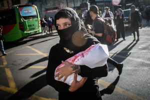 A female protester carries a fake kid wrapped in a fake blood-stained cloth during the demonstration. Protesters participate in a rally in the city of Valparaiso in Chile to mark the International Day of Solidarity with the Palestinian People, condemning Israel’s war on Gaza and calling for a permanent ceasefire. This day is observed annually on November 29 to remember Resolution 181, when the UN decided in 1947 to divide Palestine into two separate Jewish and Arab states.