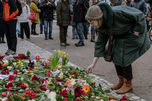 A woman places a flower at a makeshift memorial in front of the Russian embassy in Berlin following the death of Russian opposition leader Alexey Navalny.
