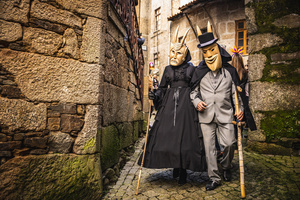 A couple dressed as Careto parade through the streets of Lazarim during carnival. In Lazarim, northern Portugal, the carnival is celebrated with a tradition known as Entrudo. During this festivity, masks of devils and demons, intricately carved in wood by the village's craftsmen, are prominently featured. The carnival parade through the streets showcases these masks, portraying ancestral scenes of Portuguese culture.