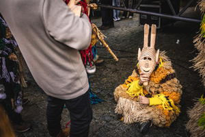 A Careto sits on the ground during the Carnival parade in Lazarim. In Lazarim, northern Portugal, the carnival is celebrated with a tradition known as Entrudo. During this festivity, masks of devils and demons, intricately carved in wood by the village's craftsmen, are prominently featured. The carnival parade through the streets showcases these masks, portraying ancestral scenes of Portuguese culture.