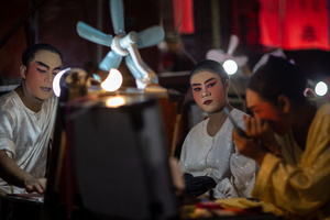 Thai performers from the "Tie Kia Tong Chia Sung Hiang" Chinese Teochew Opera troupe apply make up in the backstage before going on stage during the birthday celebration of Godfather Pung Tao Kong festival in Chiang Mai. The Chinese Opera is a spectacle combining song, dance, acting, poetry and martial arts. The performers wear colorful costumes and elaborate make-up. The Chinese Opera in Thailand is Teochew opera or Chiuchow opera, one of the many variants of its kind, originating from southern China. The traditional Chinese Opera has been a part of Thai culture for centuries, with performances taking place on various occasions in the Thai-Chinese community.