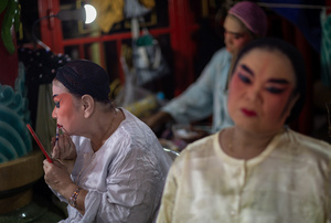 Thai performers from the "Tie Kia Tong Chia Sung Hiang" Chinese Teochew Opera troupe apply make up at the backstage before going on stage during the birthday celebration of Godfather Pung Tao Kong festival in Chiang Mai. The Chinese Opera is a spectacle combining song, dance, acting, poetry and martial arts. The performers wear colorful costumes and elaborate make-up. The Chinese Opera in Thailand is Teochew opera or Chiuchow opera, one of the many variants of its kind, originating from southern China. The traditional Chinese Opera has been a part of Thai culture for centuries, with performances taking place on various occasions in the Thai-Chinese community.