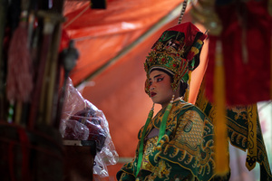 A Thai performer of the "Tie Kia Tong Chia Sung Hiang" Chinese Teochew Opera troupe prepares backstage during the birthday celebration of Godfather Pung Tao Kong festival in Chiang Mai. The Chinese Opera is a spectacle combining song, dance, acting, poetry and martial arts. The performers wear colorful costumes and elaborate make-up. The Chinese Opera in Thailand is Teochew opera or Chiuchow opera, one of the many variants of its kind, originating from southern China. The traditional Chinese Opera has been a part of Thai culture for centuries, with performances taking place on various occasions in the Thai-Chinese community.