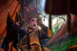A Thai performer of the "Tie Kia Tong Chia Sung Hiang" Chinese Teochew Opera troupe prepares backstage during the birthday celebration of Godfather Pung Tao Kong festival in Chiang Mai. The Chinese Opera is a spectacle combining song, dance, acting, poetry and martial arts. The performers wear colorful costumes and elaborate make-up. The Chinese Opera in Thailand is Teochew opera or Chiuchow opera, one of the many variants of its kind, originating from southern China. The traditional Chinese Opera has been a part of Thai culture for centuries, with performances taking place on various occasions in the Thai-Chinese community.