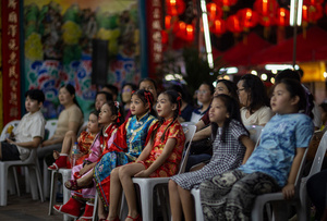 Children watch the Chinese opera performance during the birthday celebration of Godfather Pung Tao Kong festival in Chiang Mai. The Chinese Opera is a spectacle combining song, dance, acting, poetry and martial arts. The performers wear colorful costumes and elaborate make-up. The Chinese Opera in Thailand is Teochew opera or Chiuchow opera, one of the many variants of its kind, originating from southern China. The traditional Chinese Opera has been a part of Thai culture for centuries, with performances taking place on various occasions in the Thai-Chinese community.