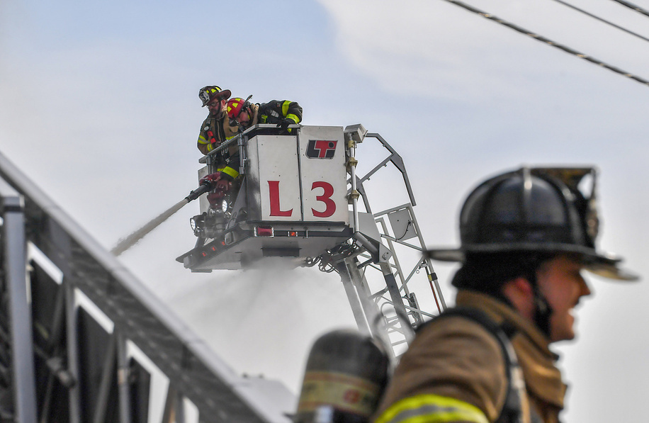 Firefighters try extinguishing a fire from Aerial lift trucks at the Dancheck Fire Extinguisher Company. In Edwardsville, a two-alarm fire swept through the Dancheck Fire Extinguisher factory on Thursday morning. The blaze also engulfed nearby businesses, including Dancheck's Extinguisher Services and NEPA Mixed Martial Arts. Despite efforts from nearly 60 firefighters, water supply issues hindered extinguishing the flames, resulting in the complete loss of the factory building. No injuries were reported.