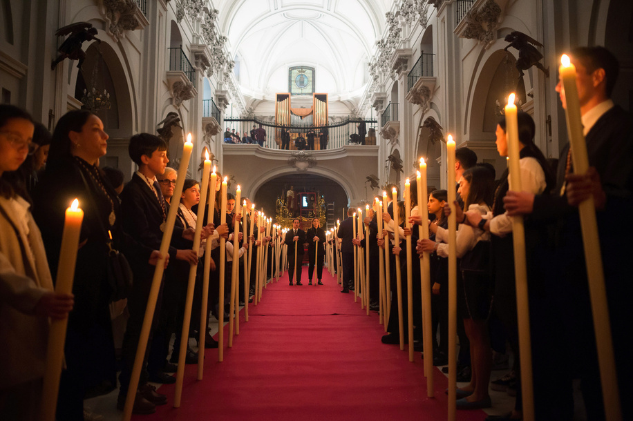 Penitents from the 'Humildad' brotherhood are seen holding candles as they take part in the cloistral transfer of the statue of Christ to its float inside Santuario de la Victoria church, before the start of Holy Week on Palm Sunday.